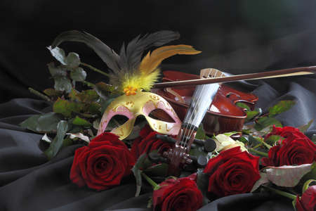 violin, a mask and a rose on a black backgroundの写真素材