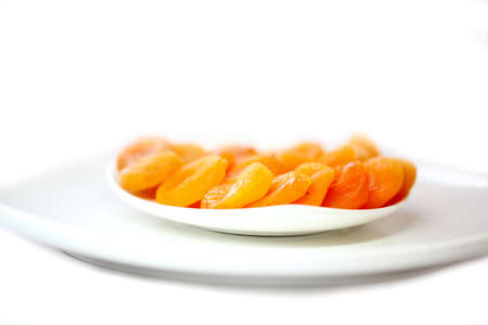 dried apricots in white plate isolated on whiteの写真素材