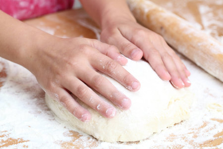 Woman hands knead the dough