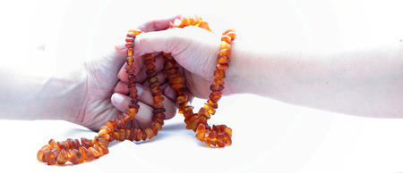 hands of men and women with an amber necklace