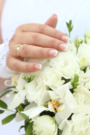 Hand of the bride on the wedding bouquet of orchidsの写真素材