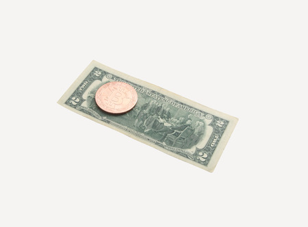 on a banknote 2 dollars coin bitcoin. Photo isolated on white