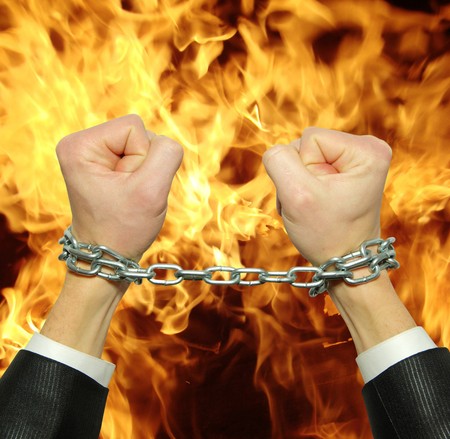 Hands in chains on a fire  background                      の写真素材