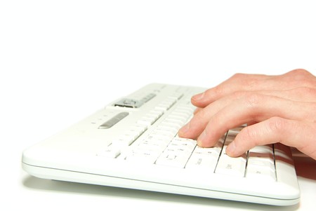 male hands typing on a white computer keyboard