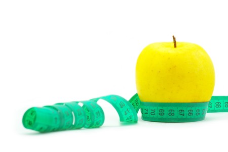 yellow apple and measuring tape on whiteの写真素材