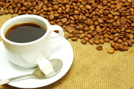 white cup with coffee costing on a coffee grainの写真素材