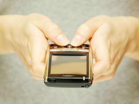 a hands holding a mobile phone for support       の写真素材