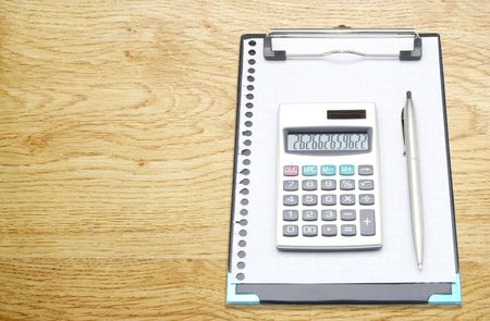 calculator and pen on a wood  background  の写真素材