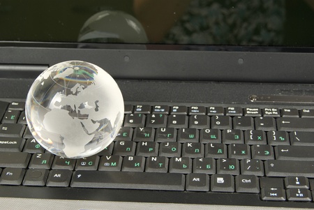 glass globe placed on a laptopの写真素材