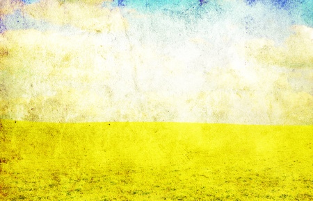 grunge image of green field and blue skyの写真素材