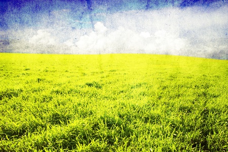 grunge image of green field and blue skyの写真素材