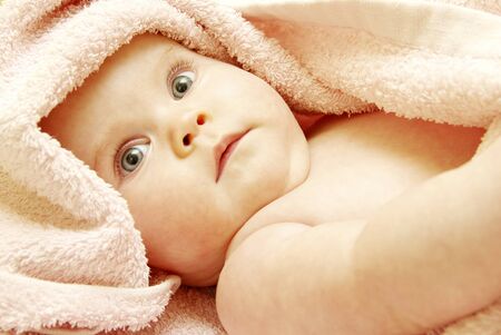 baby looking out from under blanket