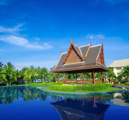 tropical swimming pool with coconut tree and white umbrellaのeditorial素材