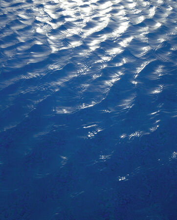 Blue water with sun reflectionsの写真素材
