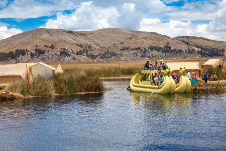 PERU - MAY 11, 2015: Unidentified women in traditional dresses welcome tourists in Uros Islandのeditorial素材