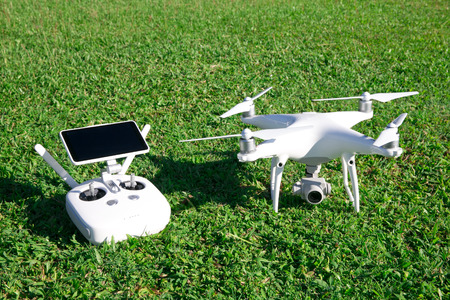 drone quad copter with high resolution digital camera and its remote control pad with smartphone on...