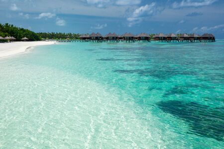 beach with water bungalows at Maldivesの写真素材