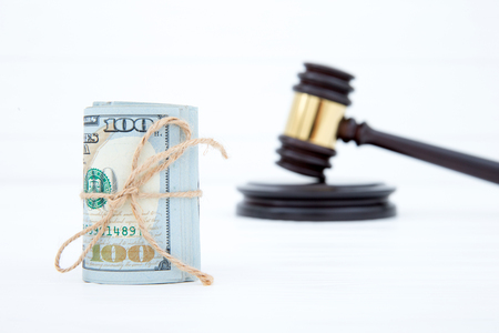 judge gavel and money on brown wooden table conceptの写真素材