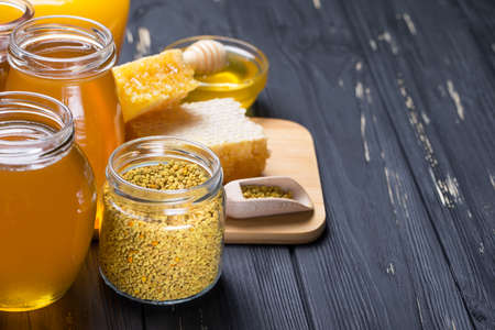 Honey in jar with honey dipper on wooden background