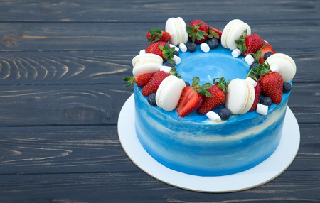 Sweet cake with strawberries on plate on grey wooden background