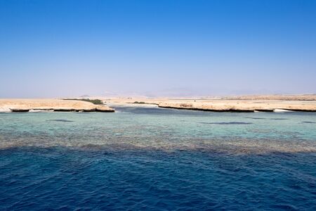 blue sky over calm sea with sunlight reflectionの写真素材