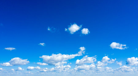 white fluffy clouds with rainbow in the blue skyの写真素材