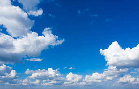 white fluffy clouds with rainbow in the blue skyの写真素材