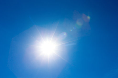 sun in sky with white cloudsの写真素材