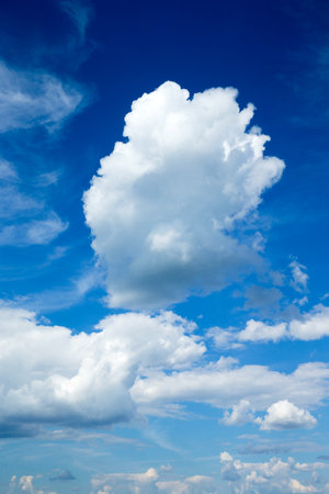 white fluffy clouds with rainbow in the blue skyの写真素材