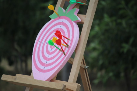 Playing darts on a strawberry shaped dart board outdoorの写真素材