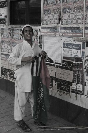 PAKISTAN_KARACHI_Religious teenager  boy show big smile whilefising his party flag 20 April 2012   (PHOTO BY ILYAS DEAN/PAK IMAGES} のeditorial素材
