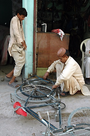 KARACHI/PAKISTAN_ Pakistani struggle for daily life male own Wafash cycle works and senior smoking water pipe ,since sneior has no plce to go in their free time there are no senior home, most  of senior spend time on shop or in street Azam basti 26 Sept. のeditorial素材