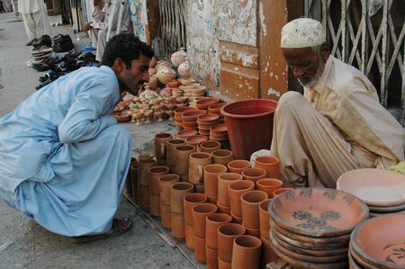 KARACHI/PAKISTAN_  Pakisani eldlery male selling  Pottery mug made clay 31 Oct 2012      のeditorial素材