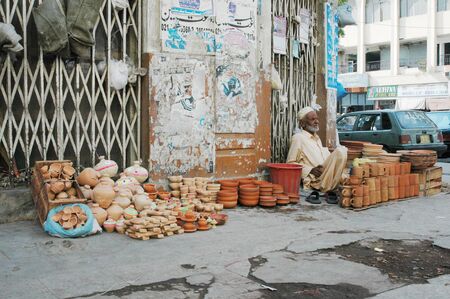 KARACHI/PAKISTAN_  Pakisani eldlery male selling  Pottery mug made clay 31 Oct 2012      のeditorial素材