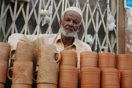 KARACHI/PAKISTAN_  Pakisani eldlery male selling  Pottery mug made clay 31 Oct 2012       のeditorial素材