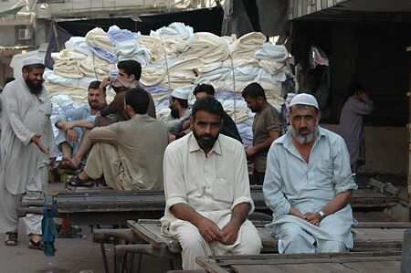 KARACHI/PAKISTAN_ Pakistani vendors on break and communicating via cellphone 6 Nov. 2012        のeditorial素材