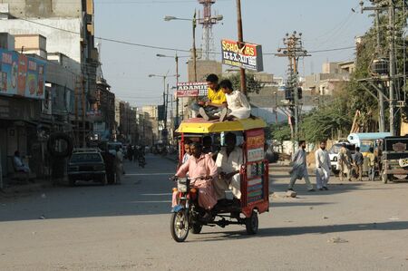 KARACHI/PAKISTAN_  Pakistani is shor´tage of state transport public system  passenger sitting on roof at motor rickshaw 26 Nov. 2012      のeditorial素材