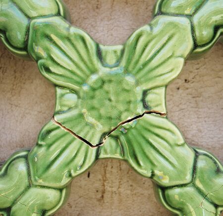 A broken ceramic green flower ornament for exterior decorationの写真素材