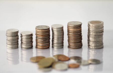 Many money coins are stacked orderly and a pile of scattered coins