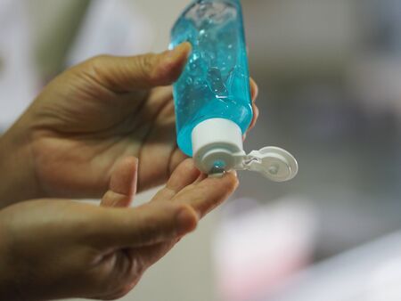women squeezing gel on finger the gel alcoholic 70 percent mixture with gelatin to prevent germs...