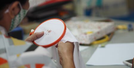 Asian women wearing fabric face mask sitting work embroidery clothingの写真素材