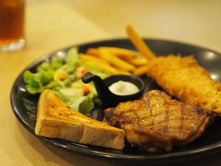 Black Pepper chicken with vegetable salad, Toast and French fries on black plate food cooked for eat