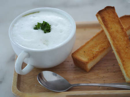 Mushroom Soup in white bowl and Garlic bread put on wooden tray, Breakfast vegan food