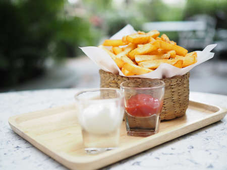 French fries, Potato chips Yellow crispy fries in wooden basket, snack delicious with tomato sauce...