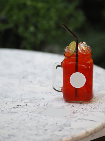 Red lemon soda water flavoured drink, Cool Drinks Beverages with ice in clear glass on white tableの写真素材