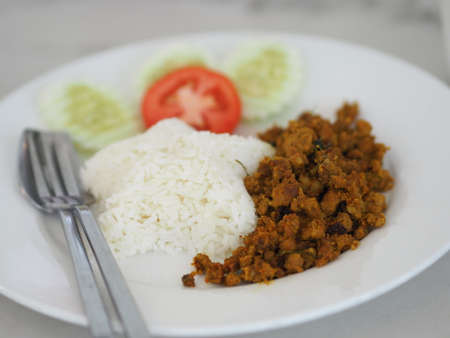 Southern Stir-Fried Pork with Yellow Curry Paste in white plate on table