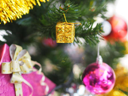 Decorated Christmas green tree decorations have Gift box gold red ball hanging pine, leaves on blurred of backgroundの写真素材