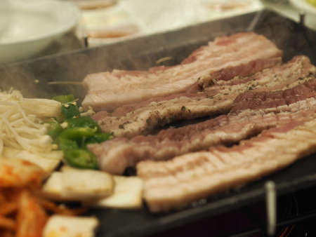 grilled pork is on the pan in Thai style, Thai buffet with pork, chicken and other meats, cooked on brass barbecue pan, pork grill, Bar-B-Q, Thai Barbecue, Korean Barbecue in Thai Style, Thai Barbecue Buffet, Thai BBQ buffet, ThaiBBQ or Yakiniku food PORK PANの写真素材