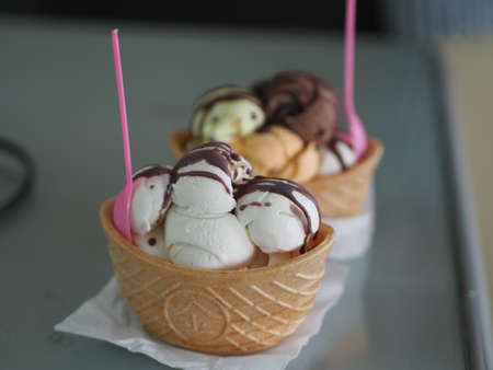 Chocolate, orange Thai tea, coconut milk ice cream in a crispy waffle cup on the mirror table