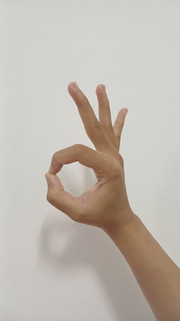 Close up Asian female hand show pinch gesture made, Ok sign finger arm and hand isolated on a white...